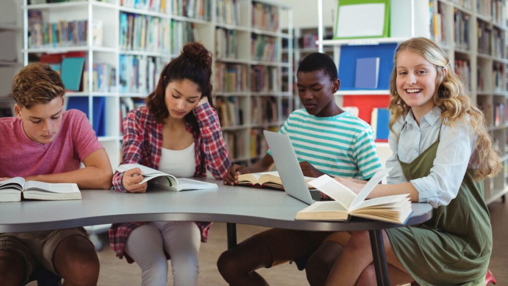 Vier lezende tieners in een bibliotheek