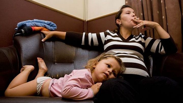 Rokende vrouw in het bijzijn van een jong kind