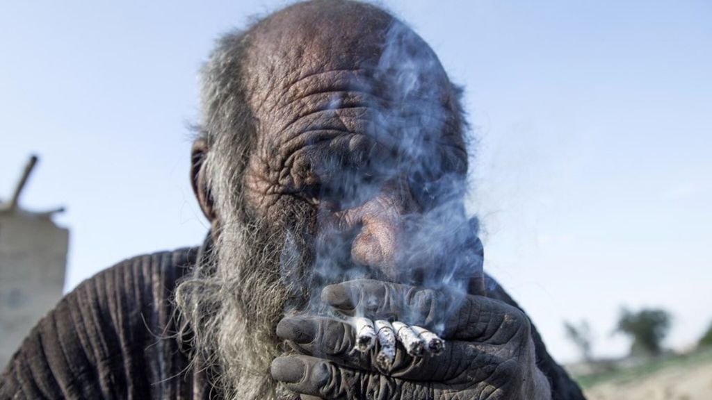 Close-up van man die 4 sigaretten tegelijk rookt.