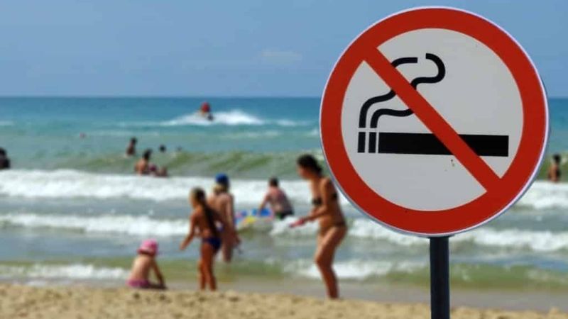 strand met badgasten en een bord Verboden te roken